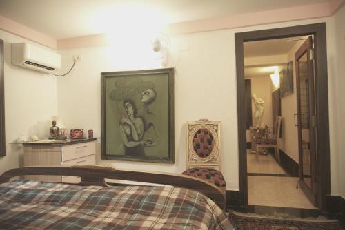 a bedroom with a bed and a painting on the wall at Reena's Lodge in Kolkata