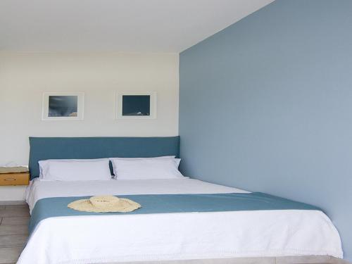 a bedroom with a large bed with a hat on it at Avanti in Ios Chora