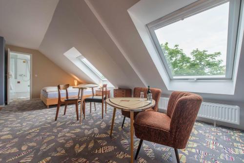 a room with two tables and chairs and a window at Klassik Appartements in Helgoland