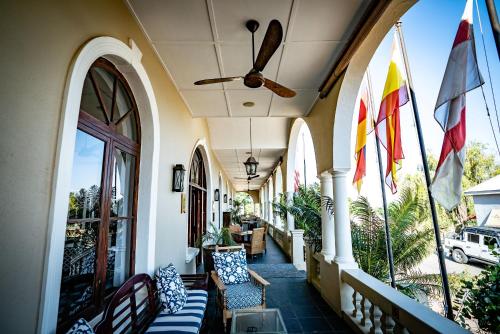 a porch with chairs and flags on a building at The Royal Hotel in Riebeek-Kasteel