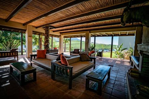 a living room with a couch and tables on a patio at The Royal Hotel in Riebeek-Kasteel