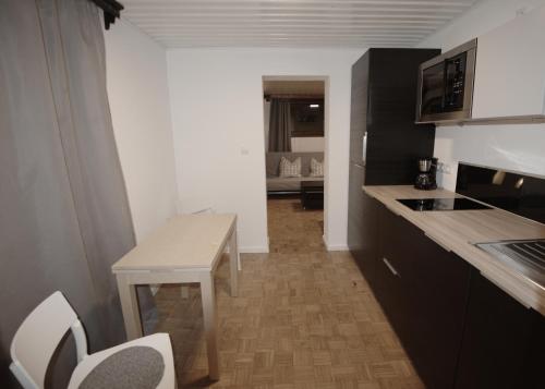 eine kleine Küche mit einem Tisch, einem Tisch und Stühlen in der Unterkunft Apartment ILWA in Schladming