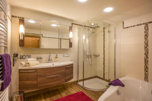 a bathroom with a tub and a sink and a shower at Apartments Obergraferhof in Innervillgraten
