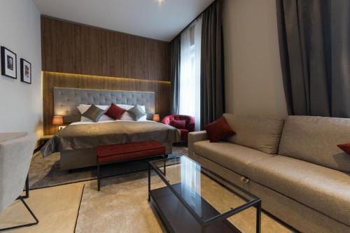 Habitación de hotel con cama y sofá en Dežman Luxury Center, en Zagreb