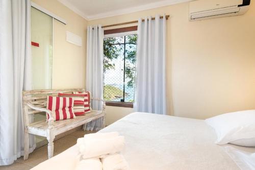 a bedroom with a bed and a window at Pousada La Dolce Vita in Búzios