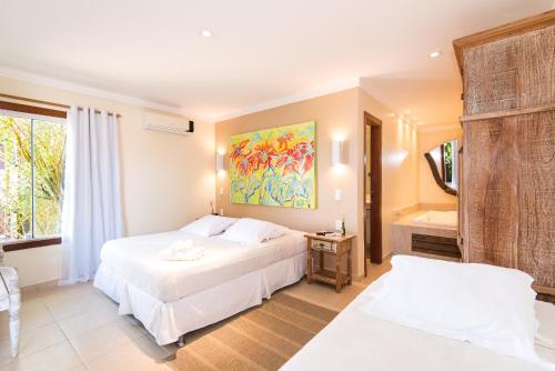 a hotel room with two beds and a bathroom at Pousada La Dolce Vita in Búzios