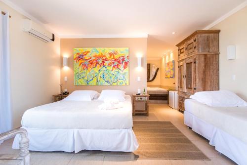 a bedroom with two beds and a painting on the wall at Pousada La Dolce Vita in Búzios