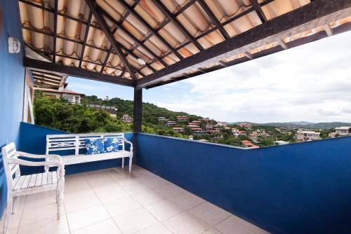 a balcony with a bench and a blue wall at Pousada La Dolce Vita in Búzios