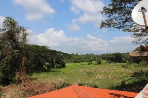 a view of a field with an orange roof at White House Family Stay in Maspota