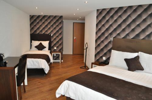 - une chambre avec 2 lits et une grande tête de lit dans l'établissement Hotel de Savoie, à Morges