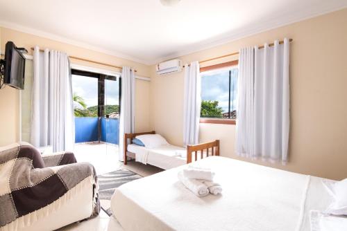 a hotel room with two beds and a couch at Pousada La Dolce Vita in Búzios