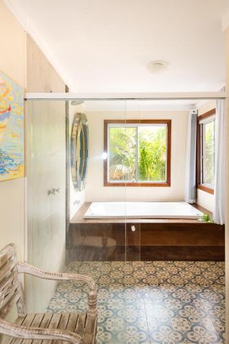 a bathroom with a tub and a window at Pousada La Dolce Vita in Búzios