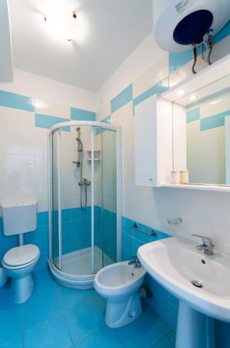 a blue and white bathroom with a toilet and a sink at Krystall in Bibione