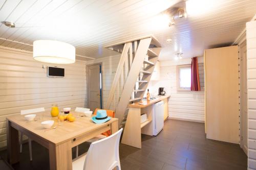 une petite maison avec une salle à manger et un escalier dans l'établissement Camping Village Le Vieux Port*****, à Messanges