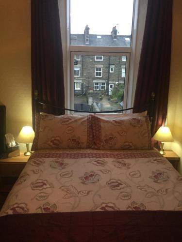 a bedroom with a bed with a large window at Westbury House in Windermere