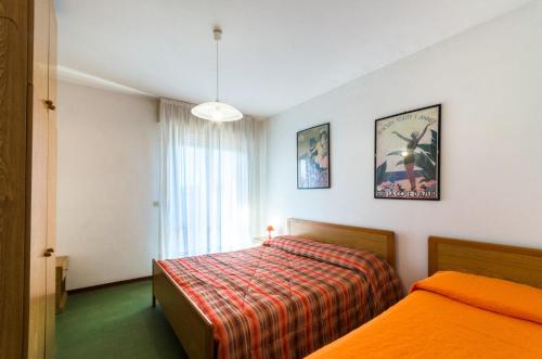a hotel room with two beds and a window at Linz in Bibione