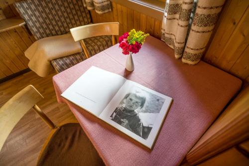 a picture of a child on a table with a vase of flowers at Apartments Obergraferhof in Innervillgraten
