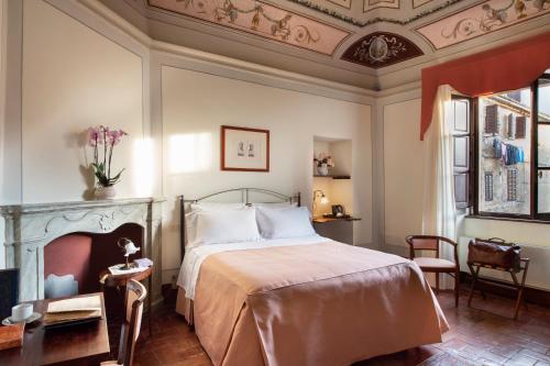 1 dormitorio con cama y techo artesonado en Hotel L'Antico Pozzo, en San Gimignano