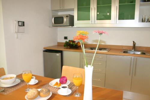 a kitchen with a table with a vase with flowers at Hotel Piedraluna in Guatemala