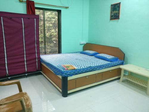 um quarto com uma cama com paredes azuis em Krushna Kunj Holiday Home em Alibaug