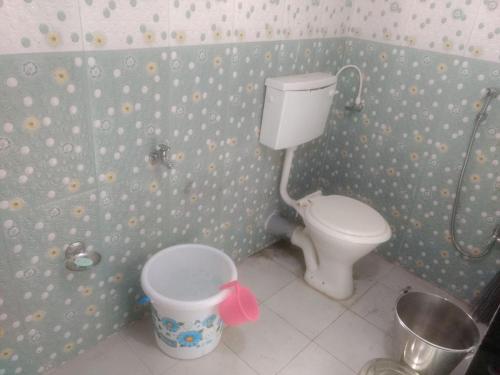 a bathroom with a toilet and a bucket in it at Krushna Kunj Holiday Home in Alibaug