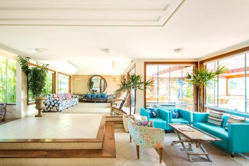a living room with blue furniture and windows at Pousada La Dolce Vita in Búzios