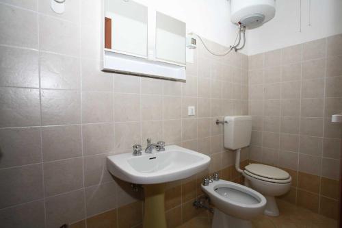 een badkamer met een wastafel en een toilet bij Perla in Bibione