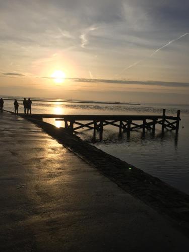 a group of people walking on the beach at sunset at Nordseeperle Husum in Husum