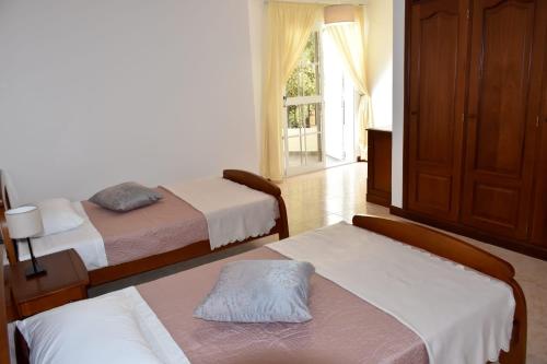 a bedroom with two beds and a window at Mansion Almond - SEA, SUN and a charming refuge! in Paul do Mar