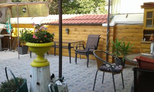 a patio with chairs and a flower pot on a pole at Szép-Lak Makó in Makó