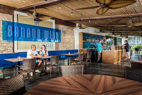 people sitting at tables in a restaurant at Margaritaville Beach Resort Playa Flamingo in Playa Flamingo