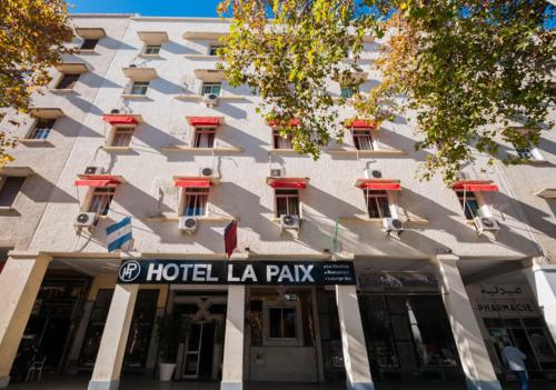 a hotel laaza building with a sign in front of it at Hotel De La Paix in Fès