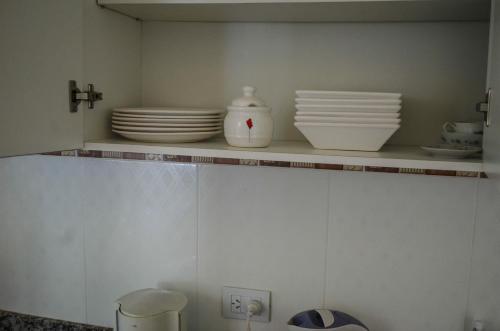 a shelf with plates and bowls on it in a kitchen at La Casa de Liber in Tandil