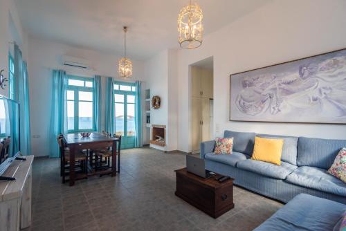 a living room with a blue couch and a table at Villa Zefyros in Pachaina