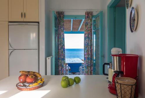 a kitchen with a table with a bowl of fruit on it at Villa Zefyros in Pachaina