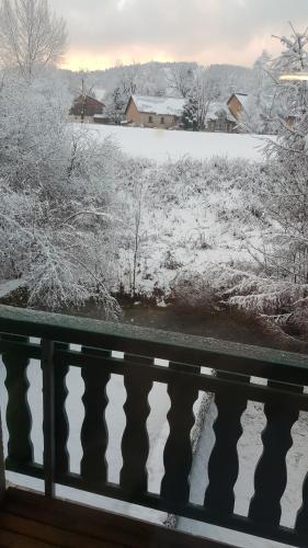 a view of a snow covered field and a river at Duplex Métabief in Métabief