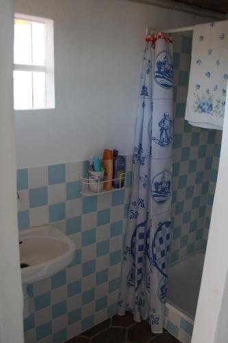 a bathroom with a shower curtain and a sink at Silves Historical House in Silves