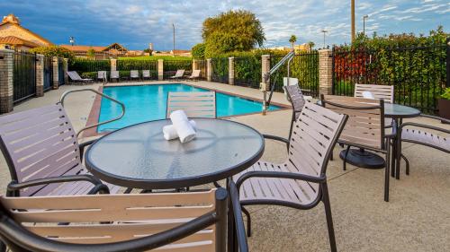 una mesa con 2 sillas y una piscina en Best Western Plus Lake Worth, en Lake Worth