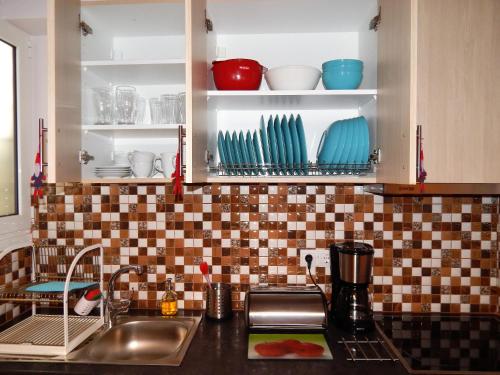 um balcão de cozinha com um lavatório e pratos nas prateleiras em ANNA em Atenas