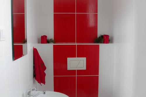 a red and white tiled bathroom with a toilet at Vysoké Tatry Gerlaška in Svätý Jur
