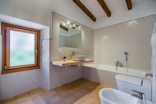 a bathroom with a tub and a sink and a mirror at Villa Ull de La Font By SunVillas Mallorca in Pollença