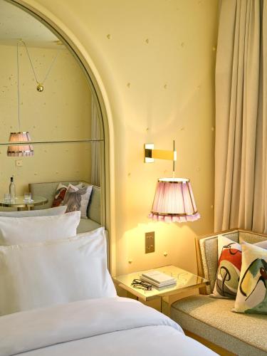 a bedroom with a bed and a couch and a lamp at 9Confidentiel in Paris