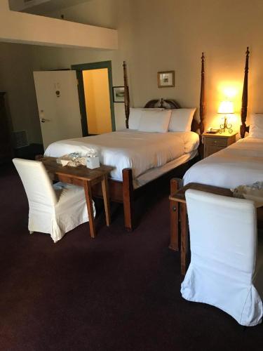 Habitación de hotel con 2 camas, mesa y sillas en The Red Lion Inn, en Cohasset