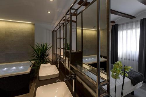 a bathroom with a sink and a mirror and a tub at Vinatea Suites in Morella