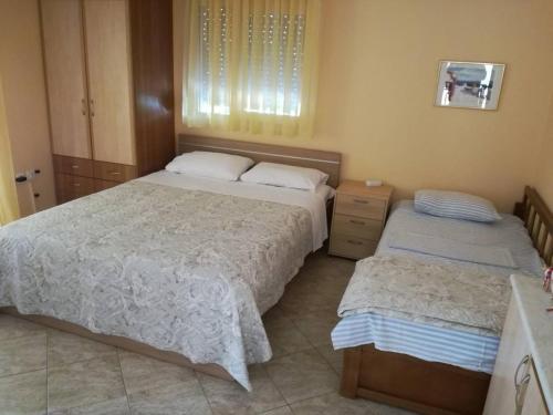 a bedroom with two beds and a window at Litsa 1 in Metamorfosi