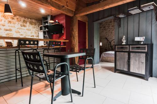 une pièce avec une table, des chaises et un lit dans l'établissement Domaine TerrOcéane, à La-Gripperie-Saint-Symphorien