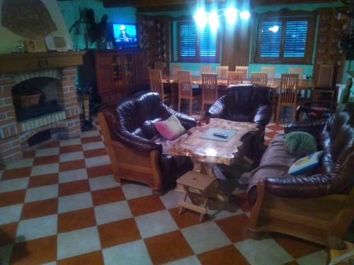 a living room with couches and a table and a fireplace at KRAJNA KUĆA ZA ODMOR in Čačinci