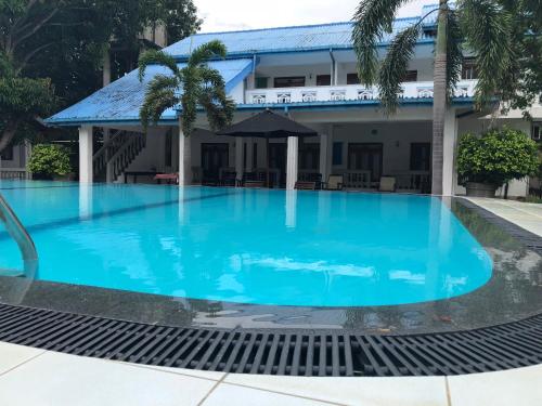 a large blue swimming pool in front of a building at The Kent in Tissamaharama