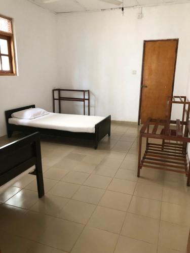 a room with two beds and two chairs in it at The Kent in Tissamaharama
