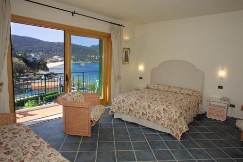 a bedroom with a bed and a balcony with a view at Hotel Danila in Portoferraio